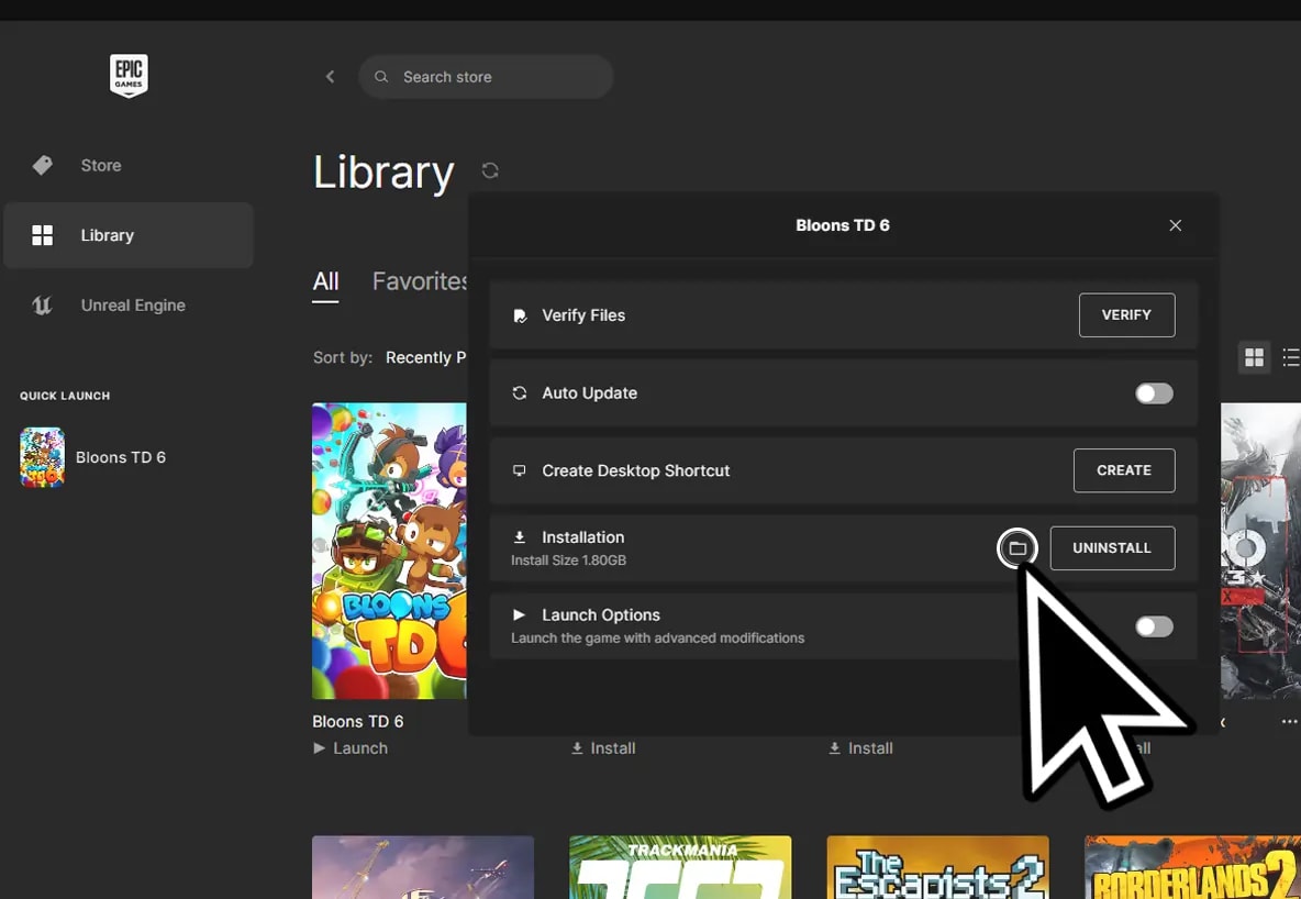 Epic Games library interface with a cursor pointing to the folder icon to open the game directory for Bloons TD 6, illustrating game management options including verification and creating desktop shortcuts.