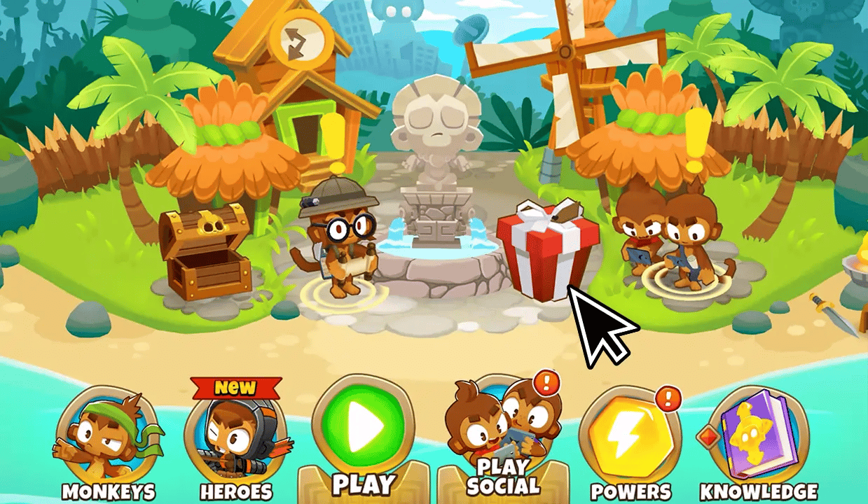 BTD6 main menu with a cursor pointing at a gift box located near the Explorer Monkey. The background shows a village setting with various monkeys and menu options, including Monkeys, Heroes, Play, Play Social, Powers, and Knowledge.